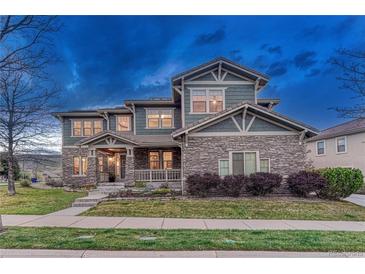 Charming two-story home with stone and siding exterior, landscaped front yard, and covered porch at 10459 Rivington Ct, Lone Tree, CO 80124
