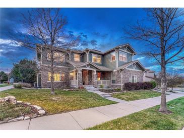 Charming two-story home with stone accents, covered porch, landscaped yard, and inviting curb appeal at 10459 Rivington Ct, Lone Tree, CO 80124