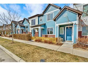 Charming blue townhomes with well-maintained lawns and sidewalks offer inviting curb appeal at 8065 E 21St Ave, Denver, CO 80238