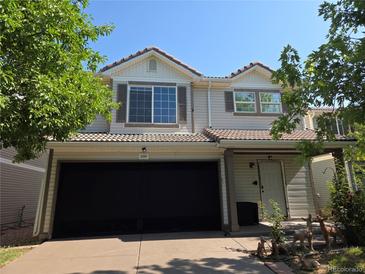 Two-story home featuring a covered front porch, shutters, and a two-car garage at 21319 Randolph Pl, Denver, CO 80249