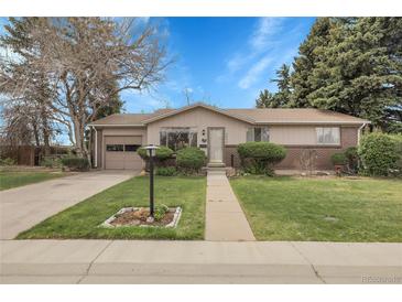Charming single-story home featuring a well-manicured lawn and inviting brick accents at 6832 S Birch Way, Centennial, CO 80122