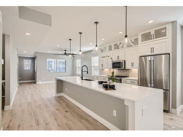 Modern kitchen with island, white cabinets, and stainless steel appliances at 6917 Kendrick Ln, Arvada, CO 80007