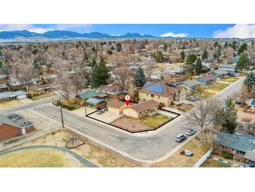Stunning aerial view of the home with mountain views, solar panels, and a spacious front yard with mature trees at 6545 Union St, Arvada, CO 80004