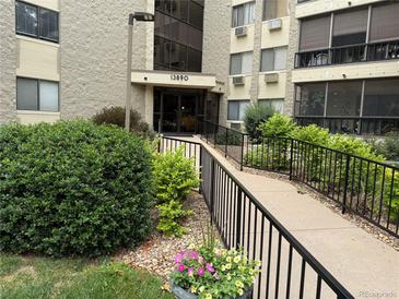 Inviting building entrance with accessible ramp, lush landscaping, and visible building number for easy identification at 13890 E Marina Dr # 602, Aurora, CO 80014