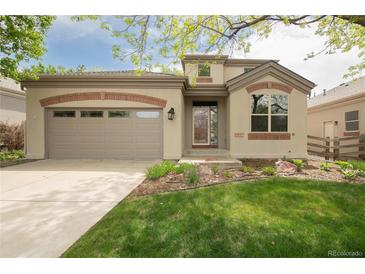 Charming two-story home featuring a two-car garage and well-manicured front yard with lawn and flower beds at 6700 W Dorado Dr # 41, Littleton, CO 80123