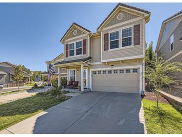 Charming two-story home featuring a large garage and covered porch with red rocking chairs at 2508 Coach House Loop, Castle Rock, CO 80109
