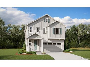 Charming two-story home with light gray siding, blue shutters, and an attached two-car garage at 9277 Truckee Ct, Commerce City, CO 80022