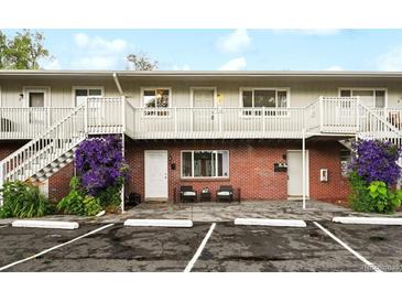 Apartment building featuring brick facade, painted stairs and railings, and charming purple flowers at 3705 Quail St # 4, Wheat Ridge, CO 80033