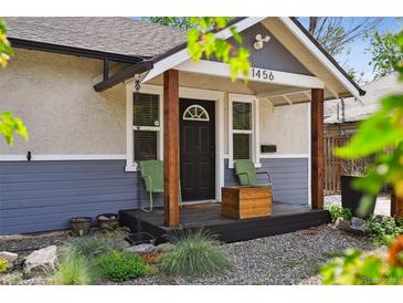 Charming front porch featuring a covered entrance, dark door, and two chairs perfect for relaxing at 1456 Syracuse St, Denver, CO 80220