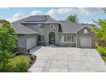 Stunning stone-accented home with a well-manicured lawn, solar panels, and a spacious concrete driveway at 6553 S Sedalia St, Aurora, CO 80016