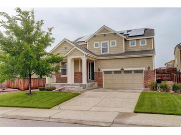 Charming two-story home with stone accents, solar panels, well-maintained lawn, and an attached two-car garage at 13351 Olive Way, Thornton, CO 80602