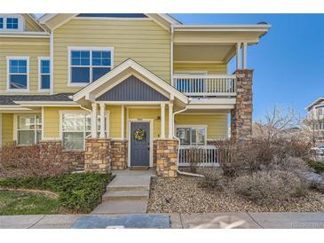 Charming two-story home featuring a welcoming front door, stone accents, and a lovely second story balcony at 9557 Pearl Cir # 204, Parker, CO 80134