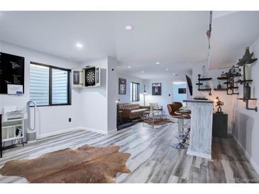 Finished basement with a modern bar area, lounge seating, and a dart board for entertainment at 25525 E 1St Ave, Aurora, CO 80018