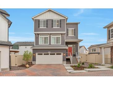 Charming two-story home featuring a red door, brick driveway, and a well-maintained front yard at 3963 N Quatar Ct, Aurora, CO 80019
