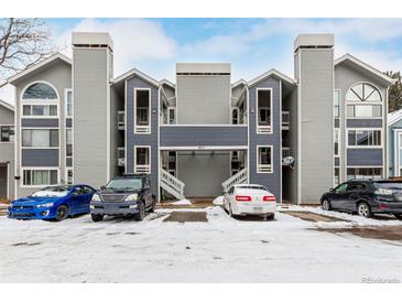 Modern condo building with covered parking and snowy front lot and beautiful blue and gray exterior at 4855 Edison Ave # 112, Boulder, CO 80301