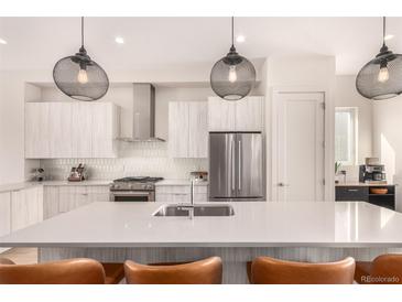 Modern kitchen features stainless steel appliances, pendant lighting, and a center island with seating at 4335 N Pecos St, Denver, CO 80211