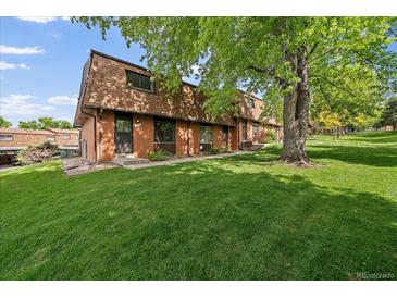 Charming brick townhouse with a well-maintained lawn and mature trees, offering a peaceful outdoor setting at 14735 W Ellsworth Ave, Golden, CO 80401