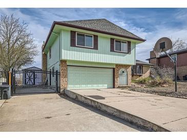 Two story home featuring brick accents, a two-car garage, and a basketball hoop at 16463 E Girard Ave, Aurora, CO 80013