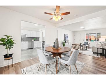 Bright dining area with a wooden table, gray chairs, and easy access to the kitchen and living room at 932 Quentin St, Aurora, CO 80011