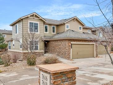 Two-story townhome with stone accents and a two-car garage at 7616 S Sicily Way, Aurora, CO 80016