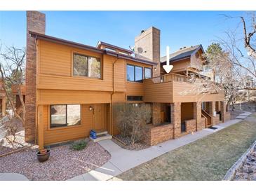 Inviting two-story townhouse featuring a private balcony, warm wood siding, and well-maintained landscaping at 9400 E Iliff Ave # 37, Denver, CO 80231