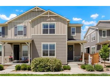 Charming townhome featuring a well-manicured lawn and neutral-toned exterior under a bright, partly cloudy sky at 17548 Bluetrail Ave, Parker, CO 80134