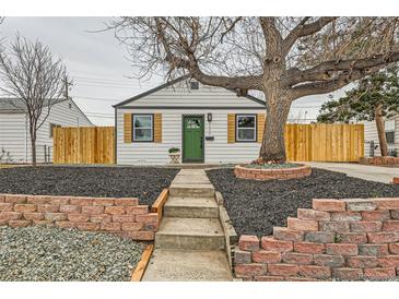 Charming home featuring a well-maintained yard, brick accents, and a welcoming green front door at 1120 Xenia St, Denver, CO 80220