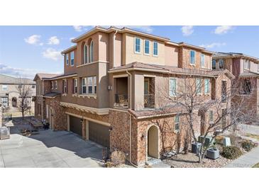 Beautiful townhouse with a brick and stucco exterior, a private balcony, and a two-car garage at 9374 Loggia St # D, Highlands Ranch, CO 80126