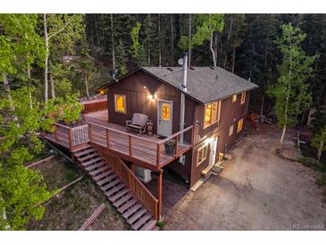 Rustic cabin with a spacious deck nestled in a serene forest setting, perfect for outdoor living at 375 Castlewood Dr, Evergreen, CO 80439