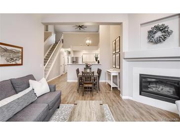 Open-concept living area featuring a fireplace, wood floors, and stairs to the second floor at 3912 S Carson St # 204, Aurora, CO 80014