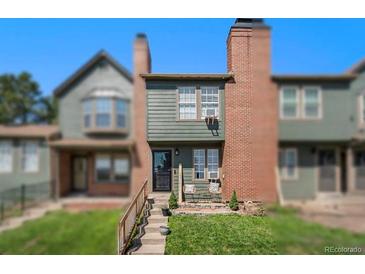 Two-story townhouse with well-maintained lawn and two chairs on the porch at 17111 E Stanford Ave # C, Aurora, CO 80015
