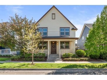 Charming two-story home featuring a welcoming front porch and meticulously maintained landscaping at 10822 E 28Th Pl, Denver, CO 80238