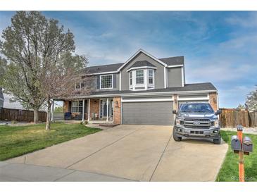 Two-story home with a gray exterior, attached garage, brick accents and a well-manicured front yard at 9786 Malachite Ct, Parker, CO 80134