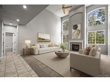 Bright living room boasts soaring ceilings, fireplace, and large windows offering plenty of natural light at 2732 Flint Ct, Superior, CO 80027