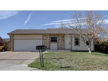 Charming single-story home with brick accents, a well-maintained lawn, and an attached two-car garage at 265 Cleveland Ct, Bennett, CO 80102