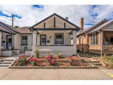 Charming bungalow with a front yard showcasing flowers and a neatly maintained landscape at 2925 E 14Th Ave, Denver, CO 80206