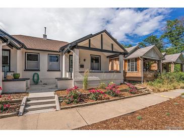 Charming white brick home with a cozy front porch and vibrant rose bushes at 2925 E 14Th Ave, Denver, CO 80206