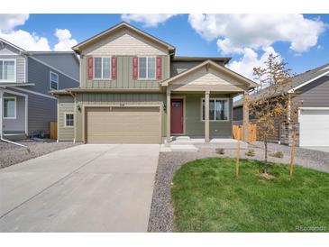 Two-story home featuring a beige garage door, red shutters, and a well-manicured front yard at 769 N Deer Park St, Watkins, CO 80137