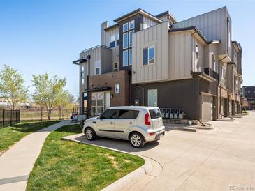 Modern townhome featuring sleek architectural design, a well-maintained lawn and convenient parking at 5004 S Platte River Pkwy, Littleton, CO 80123