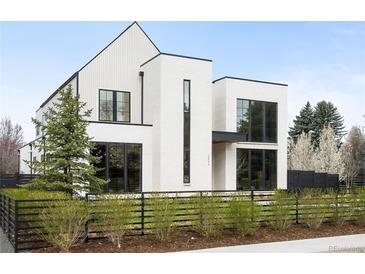 Striking modern home featuring a bright white facade, black framed windows and a minimalist landscape at 1001 S Adams St, Denver, CO 80209