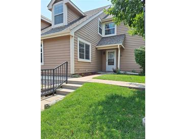 Charming townhome with well-manicured lawn, covered entryway, and beautiful landscaping at 13504 E Asbury Dr, Aurora, CO 80014