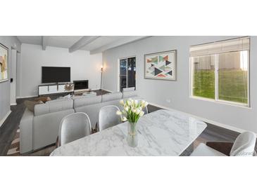 Bright dining area with marble table and seating for four, looking toward living room at 9725 E Harvard Ave # 440, Denver, CO 80231