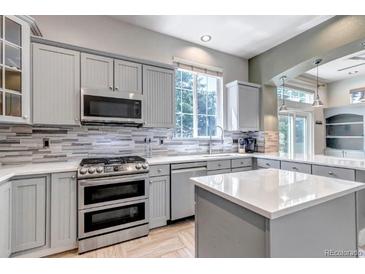 Modern kitchen featuring stainless steel appliances, gray cabinetry and a bright, window-lit space at 10609 Abilene St, Commerce City, CO 80022