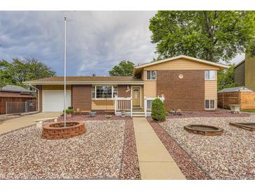 Charming brick home with a well-manicured lawn and inviting front porch at 6072 Pierson Ct, Arvada, CO 80004