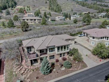 Beautiful exterior of the home featuring stone accents, landscaped yard, and a private balcony with scenic views at 5951 Rain Dance Trl, Littleton, CO 80125