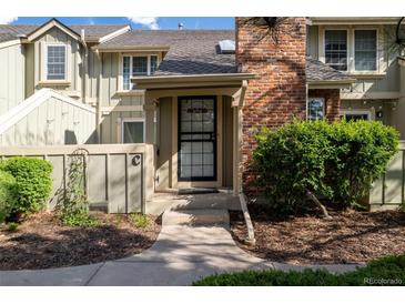 Charming townhouse with a brick chimney, covered entry and landscaped garden area at 7761 S Curtice Dr # C, Littleton, CO 80120