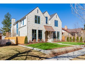 Charming stone home with manicured lawn and striking window trim at 2365 S Clayton St, Denver, CO 80210