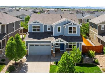 Charming two-story home with blue siding, well-manicured lawn, and an attached two-car garage in a suburban neighborhood at 10057 Des Moines St, Parker, CO 80134