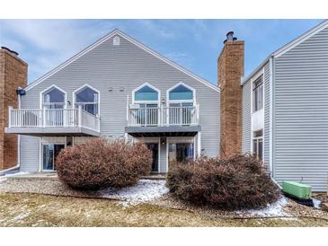 Two-story townhome featuring a chimney and upper level decks with white railing at 3337 S Monaco Pkwy # C, Denver, CO 80222