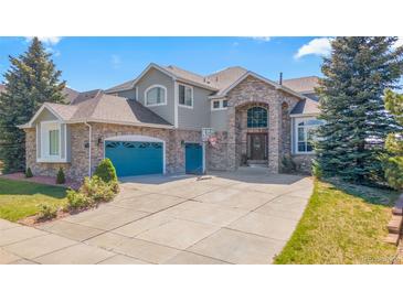 Charming two-story home with a brick facade, arched entry, and three car garage at 24022 E Jamison Dr, Aurora, CO 80016